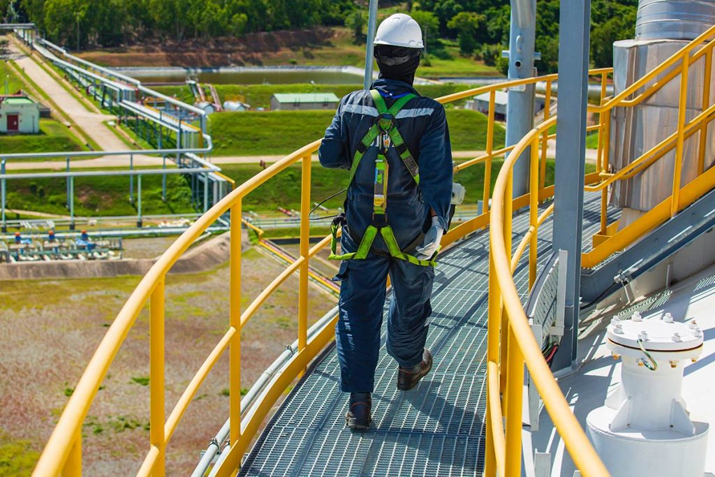 A lone worker walking on a platform with rail working at height