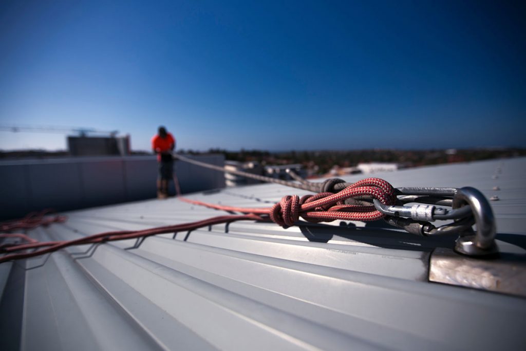 Worker connected to a fall restraint anchor point.